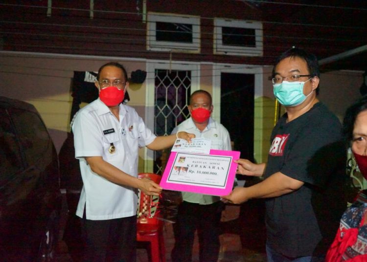 PEDULI : Bupati Royke Roring menyerahkan bantuan kepada keluarga yang tertimpa bencana kebakaran. (foto/ist)