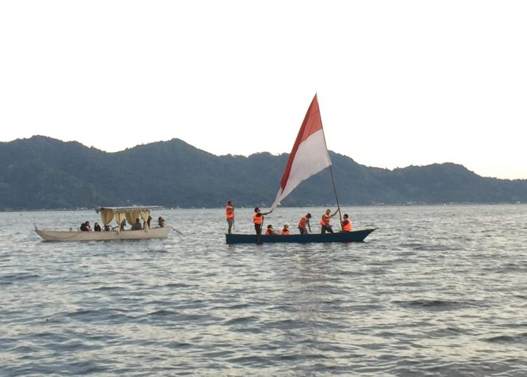 MAKNAI HARI PAHLAWAN : Nampak para pemuda mengibarkan bendera merah putih di tengah danau dengan menggunakan perahu. (foto/ist)