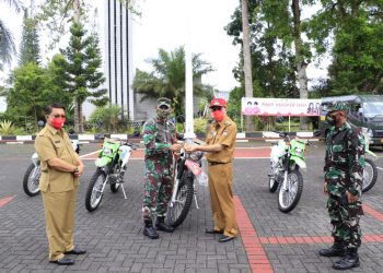 TUNJANG KINIRJA TNI : Bupati Royke Roring menyerahkan kunci kendaraan roda dua kepada Dandim. (foto/ist)
