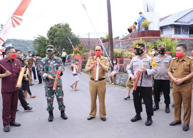 PERCONTOHAN : Bupati Royke Roring bersama Forkopimda memukul tetengkoren sebagai pencanangan Kampung Tangguh. (foto/ist)
