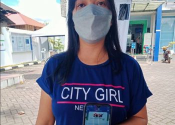 Meyfie Marini Kereh saat menunjukan aplikasi Mobile JKN di Handphone miliknya, usia berkunjung ke Kantor BPJS Kesehatan Cabang Tondano. (foto/ist)