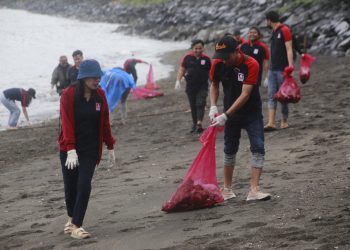 HARI PEDULI SAMPAH NASIONAL: Suasana para karyawan Alfamidi dan anggota AJI Manado, serta Mahasiswa Pencinta Alam yang mengangkut sampah plastik di pesisir pantai Manado Karangria. (foto/ist)